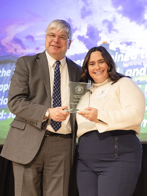 Nicole Rihn standing with Dean Sanders holding her award