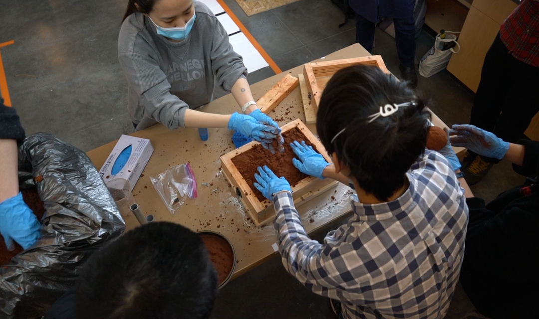 Students using a mold to make a cast