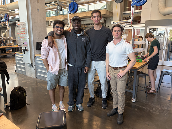 A group shot of the four students in a lab