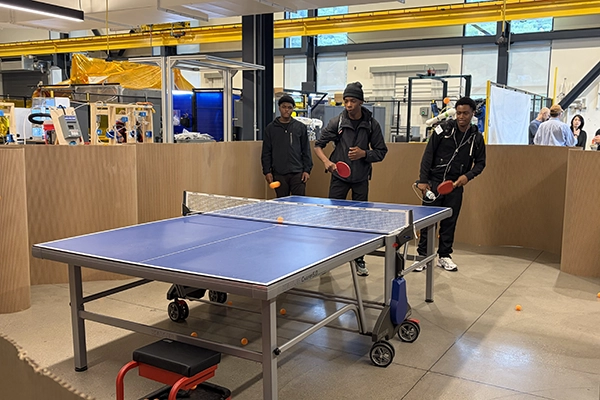 Three students playing ping pong