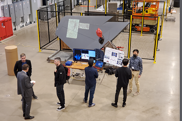 A group of people in the highbay looking at a poster presentation