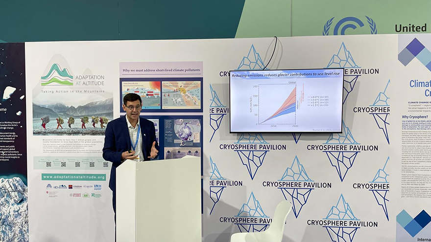 A man behind a podium presenting from a screen