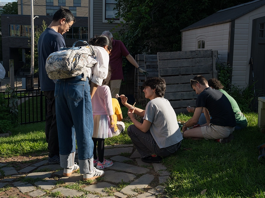A family gathers around a man showing them garlic