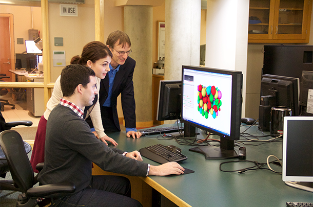A professor and two students looking at a graphic on a computer