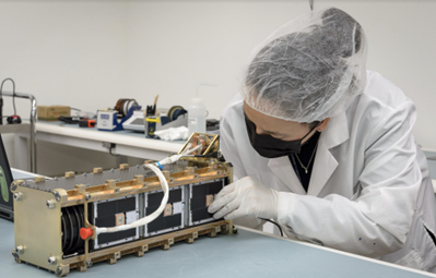 Woman working with nanosatellite on the table