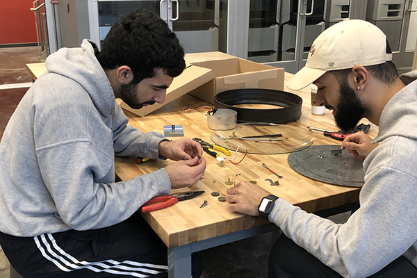 students working with clock pieces